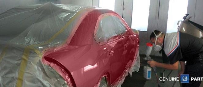 Technician painting a car